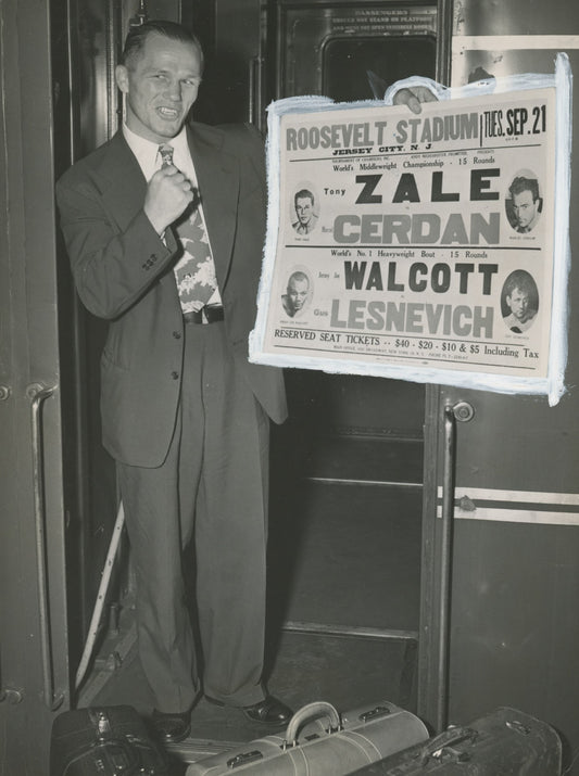 Boxer Tony Zale holding a poster of his upcoming fight