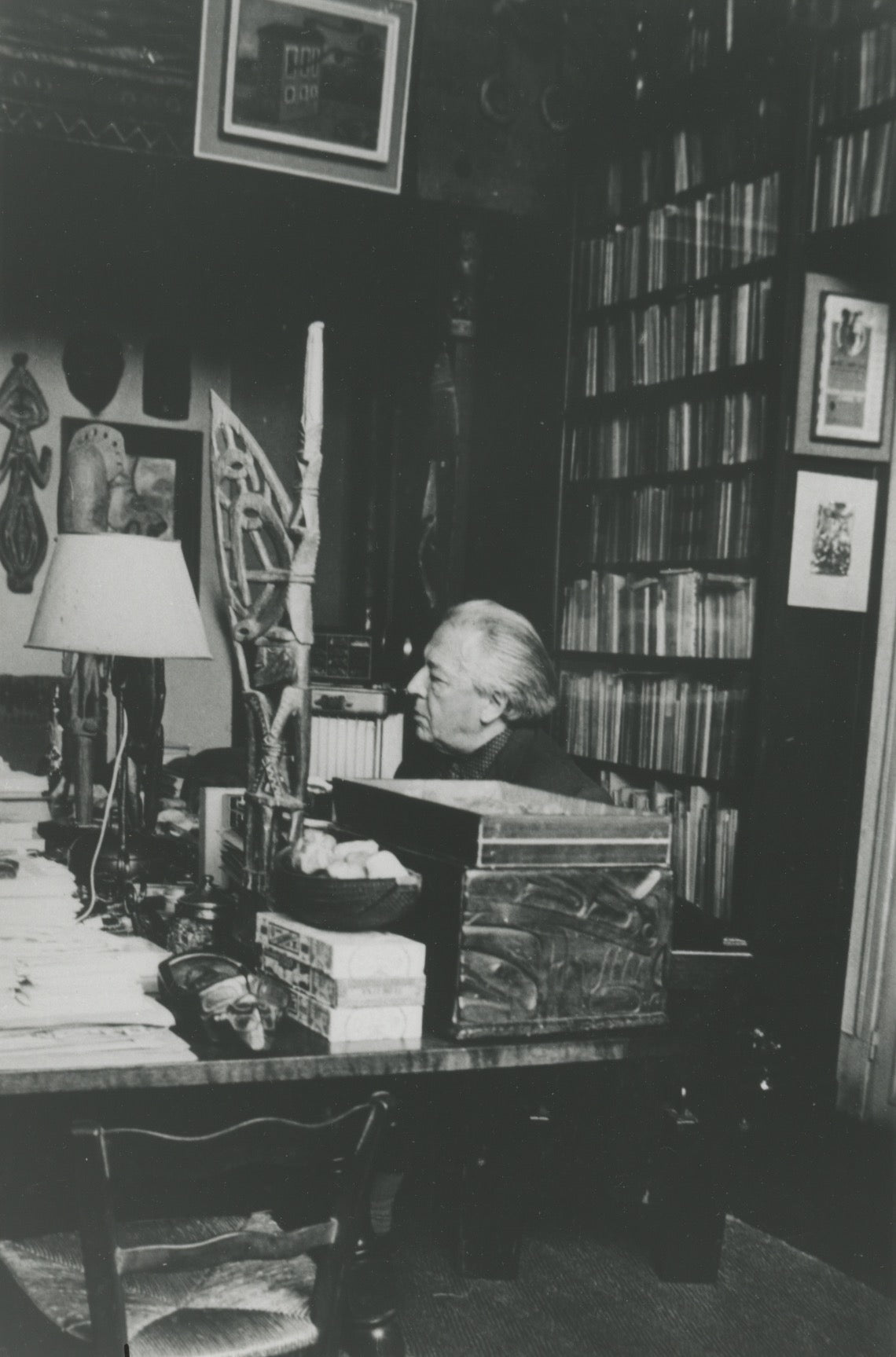 André Breton in profile, seated behind his desk