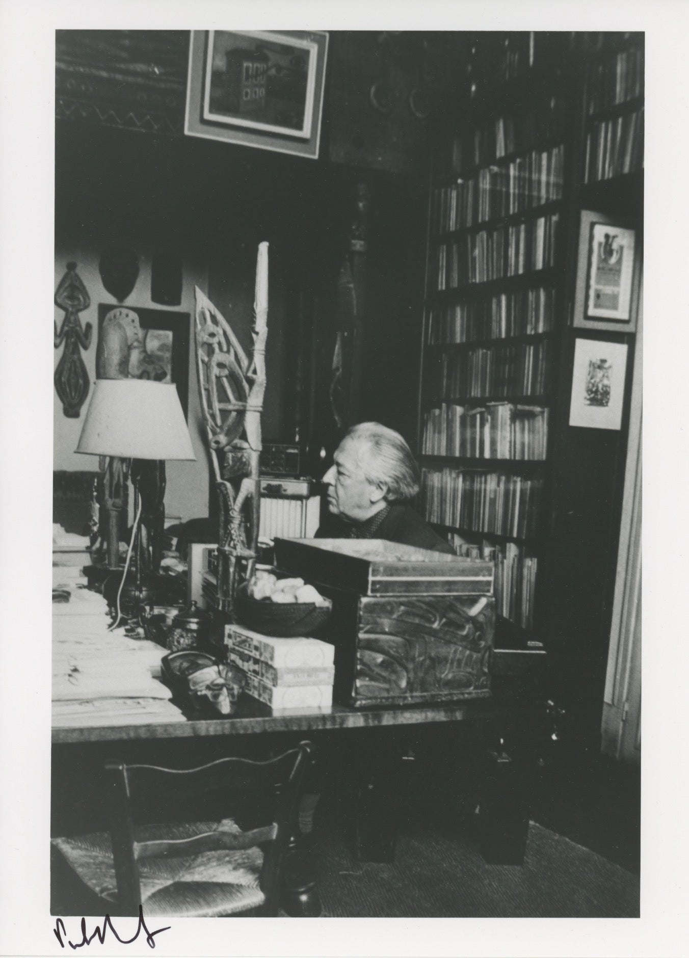 André Breton in profile, seated behind his desk